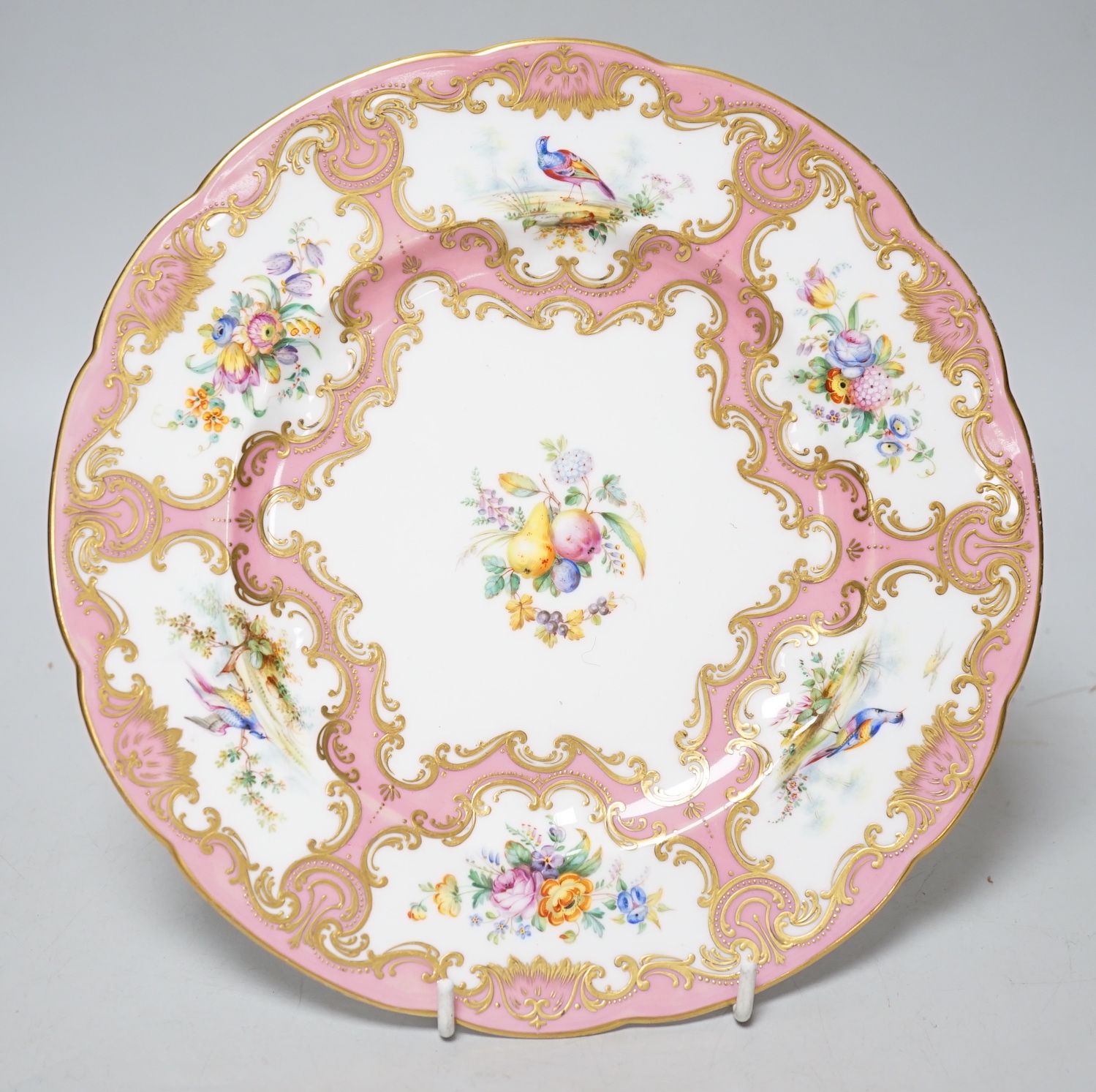 A Coalport plate painted with pink ground border, having alternating bird and flower panels and the centre with fruit and flowers, probably by Randall and Cook